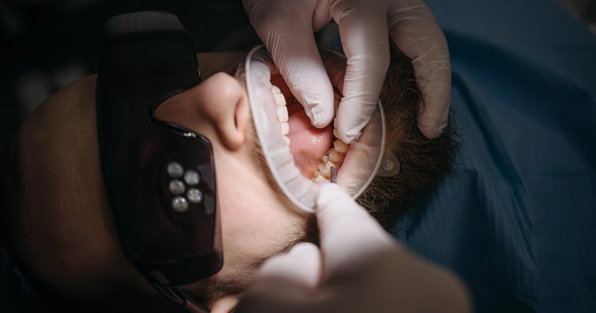 Dentista examinando sorriso e gengivas de paciente com instrumentos