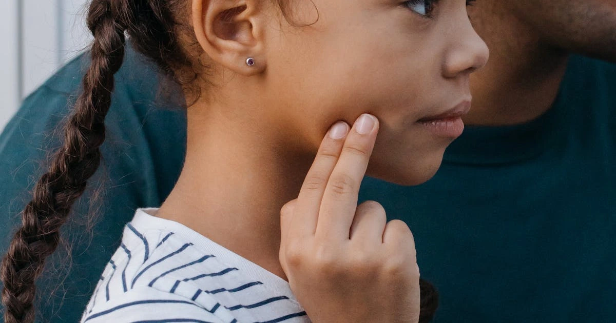 Jovem tocando a mandíbula indicando dor - sintoma de DTM